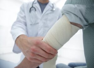 Orthopedist applying a bandage to a patient's hand in the clinic.