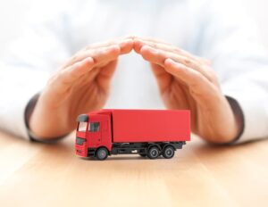 Hands protecting a red cargo delivery truck.