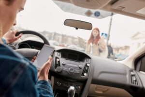 Female pedestrian lies as passed away on road by silver car as road accident. 